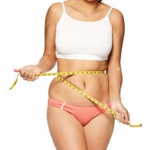 The overweight girl measures her waist